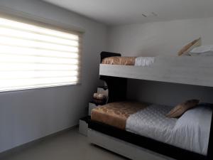 a bedroom with two bunk beds and a window at FONTAINE BLEAU in Tonsupa