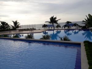 a large swimming pool with the ocean in the background at FONTAINE BLEAU in Tonsupa