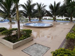 a large pool with palm trees and a fountain at FONTAINE BLEAU in Tonsupa +2 photos