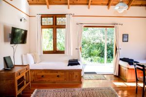 a bedroom with a bed and a large window at The Church Accommodation in Hahei