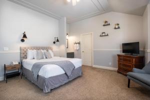 a bedroom with a bed and a tv and a couch at Hounds Tooth Inn in Oakhurst