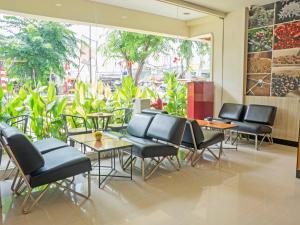 a restaurant with chairs and tables and a large window at d'primahotel Airport 1 in Tangerang