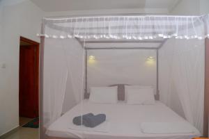 ein kleines Bett mit Baldachin in einem Zimmer in der Unterkunft THE KING APARTMENT in Hikkaduwa