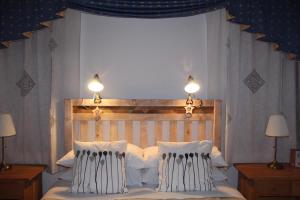 a bed with two white pillows and two lights on it at La dimora di Civita in Bagnoregio