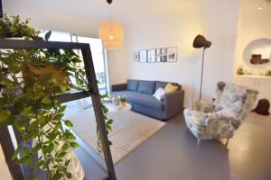 uma sala de estar com um sofá azul e uma cadeira em Limegrove Holiday Apartment em Protaras