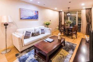 a living room with a couch and a table at Green Court Residence Jinqiao Diamond Shanghai in Shanghai