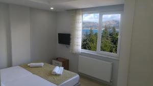 a bedroom with a bed and a window with a view at Hannapart Otel in Egirdir