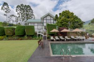 a home with a swimming pool and a house at Langdale Boutique Hotel by Amaya in Nuwara Eliya