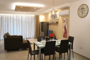 a dining room and living room with a table and chairs at Seaside Apartments in Marsaskala