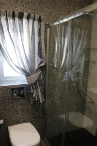 e bagno con doccia, servizi igienici e finestra. di Seaside Apartments a Marsaskala