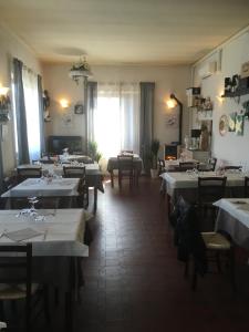 a restaurant with white tables and chairs and a room with windows at Il Ciambellino in Santo Stefano di Magra