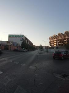 an empty street with a car parked on the side of a building at Como en Casa in Valencia