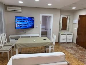 マラガにあるApartments soho, Malaga centerのテーブルと壁掛けテレビ付きの部屋