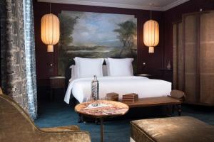 パリにあるオテル モンテクリストのベッドとテーブルが備わるホテルルームです。