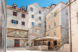 a group of buildings in a street with a restaurant at Dosud House Studios in Split