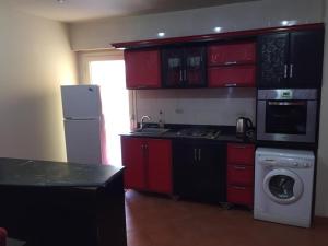 kuchnia z czerwonymi szafkami i pralką w obiekcie Chalets in Porto Sokhna - Pyramids - Families Only w mieście Ajn Suchna