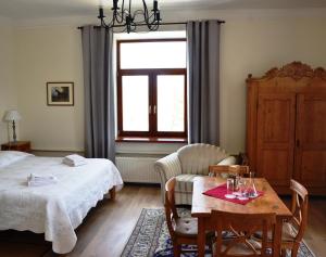 een slaapkamer met een bed, een tafel en een raam bij Hotel Grasu Pils in Cesvaine