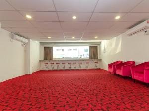 an empty room with red chairs and a red carpet at Princess Hotel Pontian in Pontian Kecil
