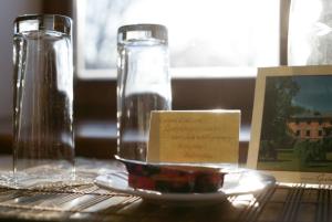 a table with two glasses and a plate of water at Hotel Grasu Pils in Cesvaine
