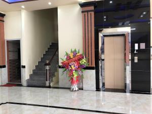 a vase of flowers in a lobby with stairs at Kien Thao Hotel in Ha Giang