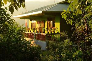 a green house with potted plants on a balcony at Parkha Homestay in Rangli
