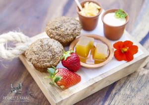 ein Tablett mit Muffins und Erdbeeren auf dem Tisch in der Unterkunft Pierneef's Kraal in Pretoria