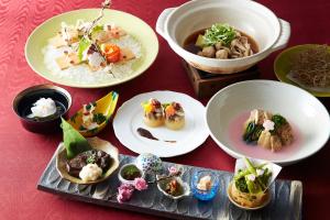 a table with plates of food and bowls of food at Gingetsu in Shimo-suwa