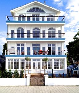 a white house with a blue roof at Strandhuus - Urlaub aan de Ostsee in Timmendorfer Strand