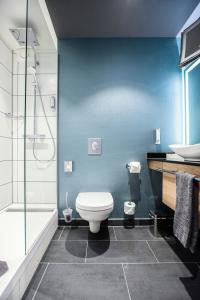 a bathroom with a toilet and a sink and a shower at Leoso Hotel Leverkusen in Leverkusen