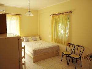 um pequeno quarto com uma cama e 2 cadeiras em Dionysos em Asprovalta