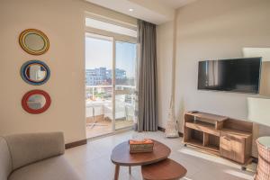 a living room with a tv and a couch and a table at Glam Hotel Nairobi - Near Westgate Mall, Westlands in Nairobi