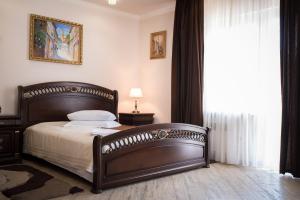 a bedroom with a bed with a wooden frame and a window at Restoran-hotel Stariy Melnik in Poltava +44 photos