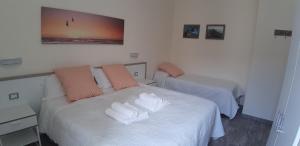 ラ・スペツィアにあるLa Branda Brin Guest Houseのベッドルーム1室(ベッド2台、タオル付)