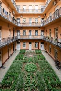 an empty courtyard of an apartment building with plants at Jewel In Buda Apartment in Budapest