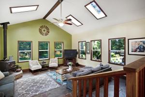 a living room filled with furniture and windows at Fort Bragg Farmhouse in Fort Bragg