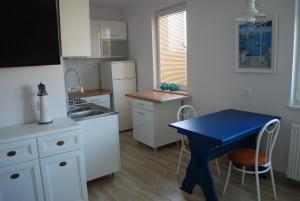 a small kitchen with a blue table and a sink at Apartament Morski in Hel