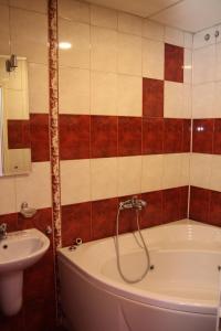 un bagno con vasca e lavandino di Hotel Color a Asenovgrad Altre 34 foto