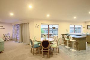 a living room with a table and chairs and a kitchen at The Ocean Dream in Rotorua