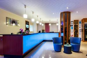 a lobby with a blue counter and blue stools at Gartenhotel Heusser in Bad Dürkheim