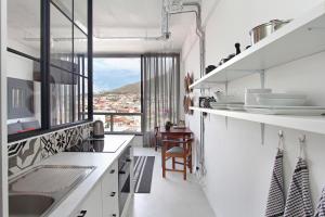 uma cozinha com balcões brancos e uma grande janela em Harbour View Apartments em Cidade do Cabo