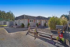 a house with a fence in front of it at Sunset Beach Cottage in Bandon