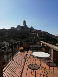 d'une terrasse avec une table et des chaises sur un balcon. dans l'établissement Albergo Bernini, à Sienne