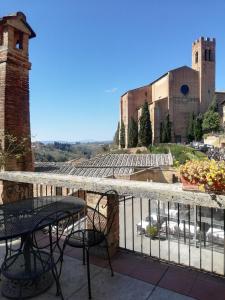 un balcón con mesa y sillas y un edificio en Albergo Bernini en Siena