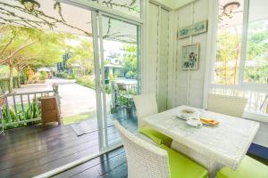 comedor con mesa y sillas en el porche en The Target Residence, en Chiang Rai