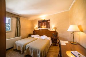 a hotel room with two beds and a table at Hotel Kent in Rome