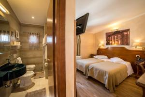 a hotel room with two beds and a bathroom at Hotel Kent in Rome