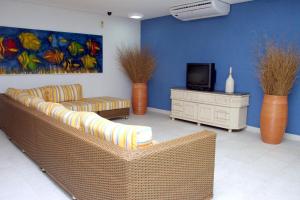 uma sala de estar com dois sofás e uma televisão em Hotel Santa Paula em Guaratuba