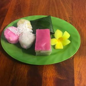 un plato verde con diferentes tipos de comida en una mesa en Chansor Community Homestay 14, en Phumĭ Trach Pôk (2)