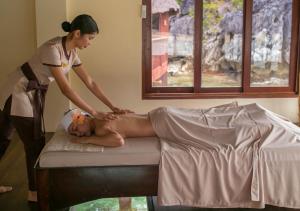 a woman is giving a woman a massage at Cauayan Boutique Private Island - formerly Cauayan Island Resort in El Nido