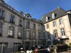 a large building with cars parked in front of it at Charme ancien & confort - cœur de ville in Auxerre